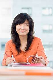 lady in orange top looking at a book