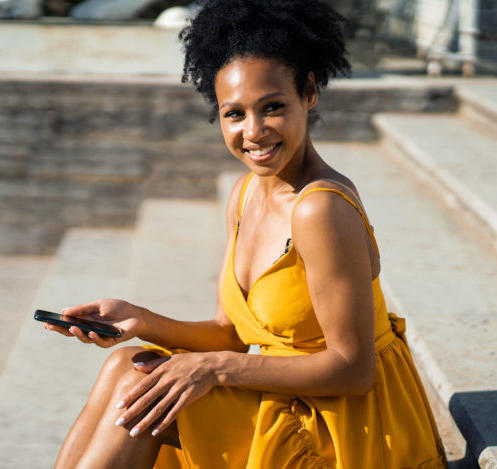 Black woman outside in a yellow dress