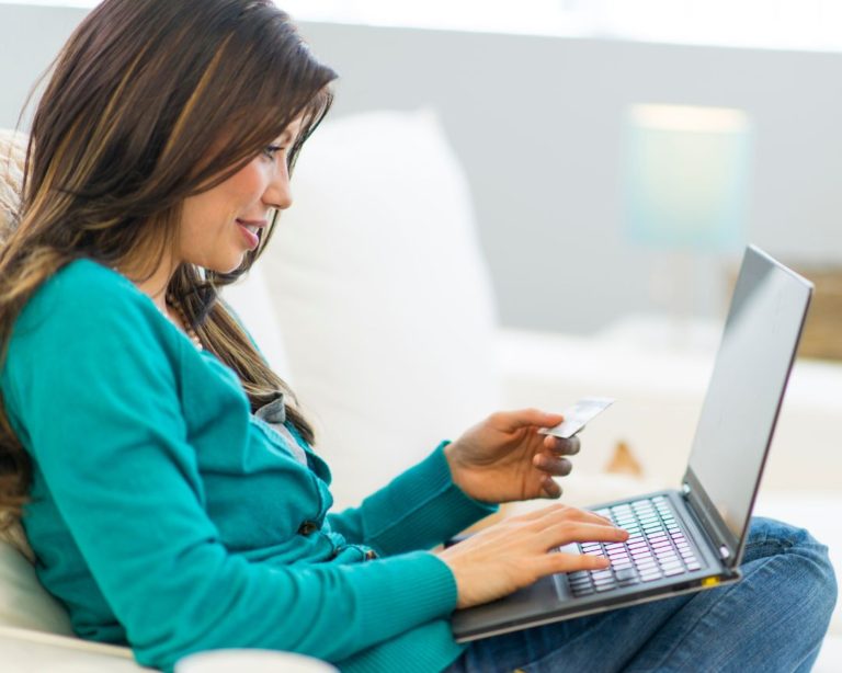 lady wearing a teal top working on the laptop