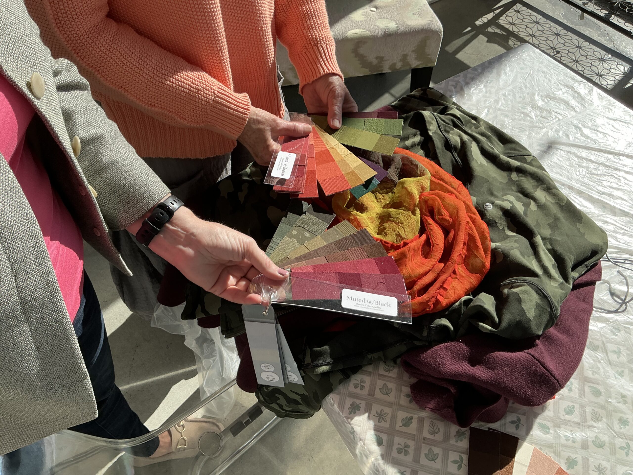 Color Consultant comparing clothing colors to fabric swatch color palette.